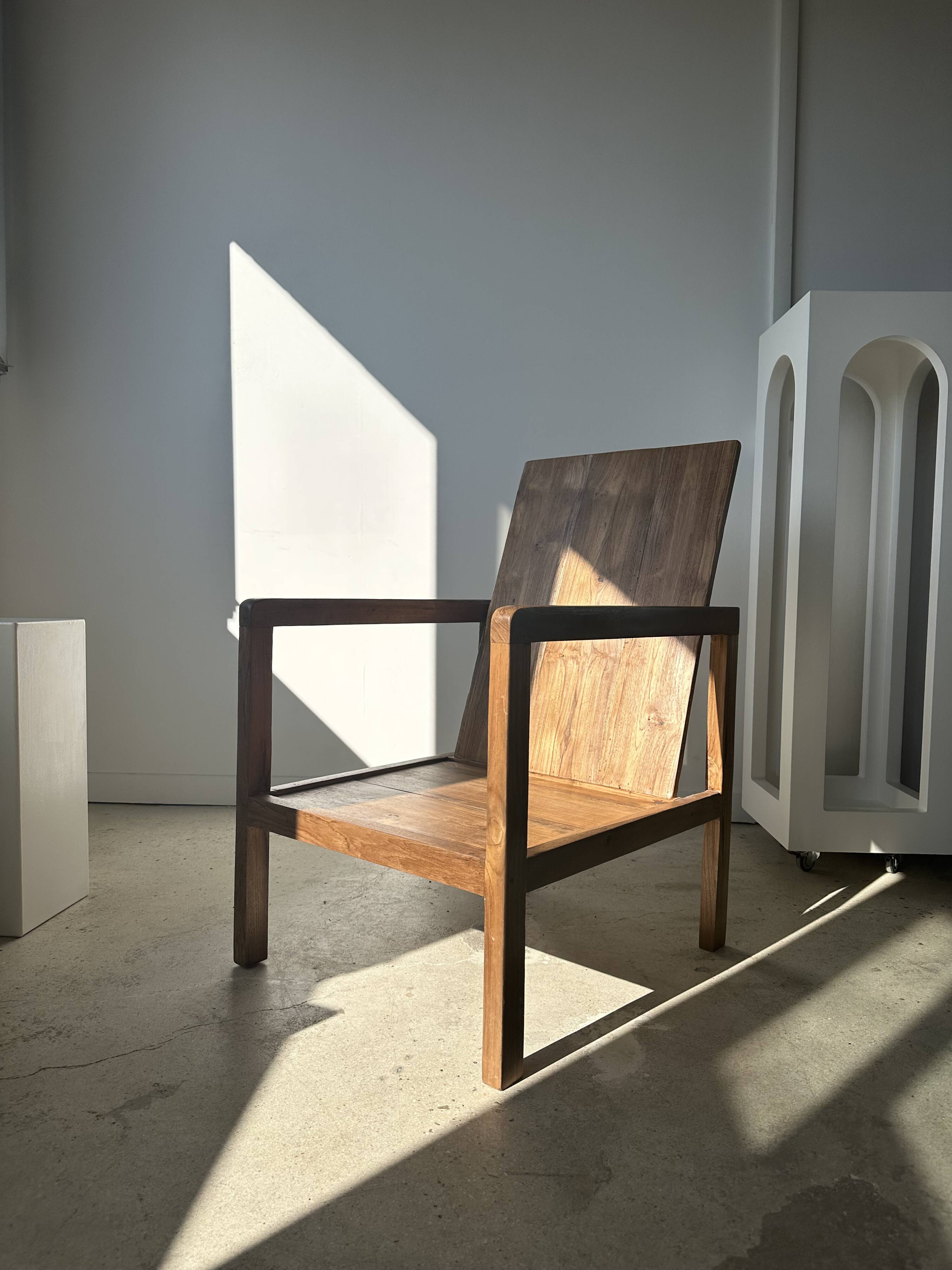 Large armchair in natural wood (teak) with a minimalist design.