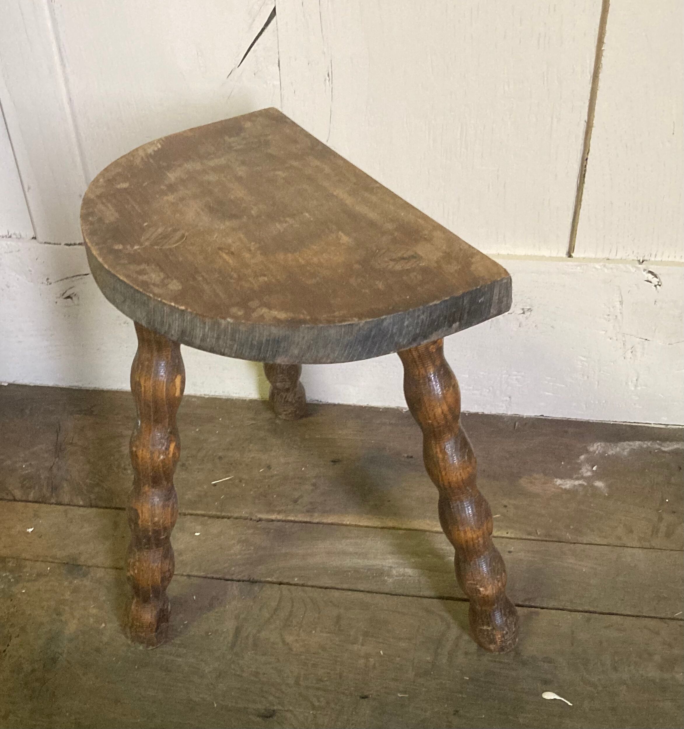 Half-moon tripod stool.