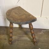 Half-moon tripod stool.