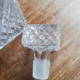 Chiseled glass whiskey decanter and its necklace marked “whiskey”