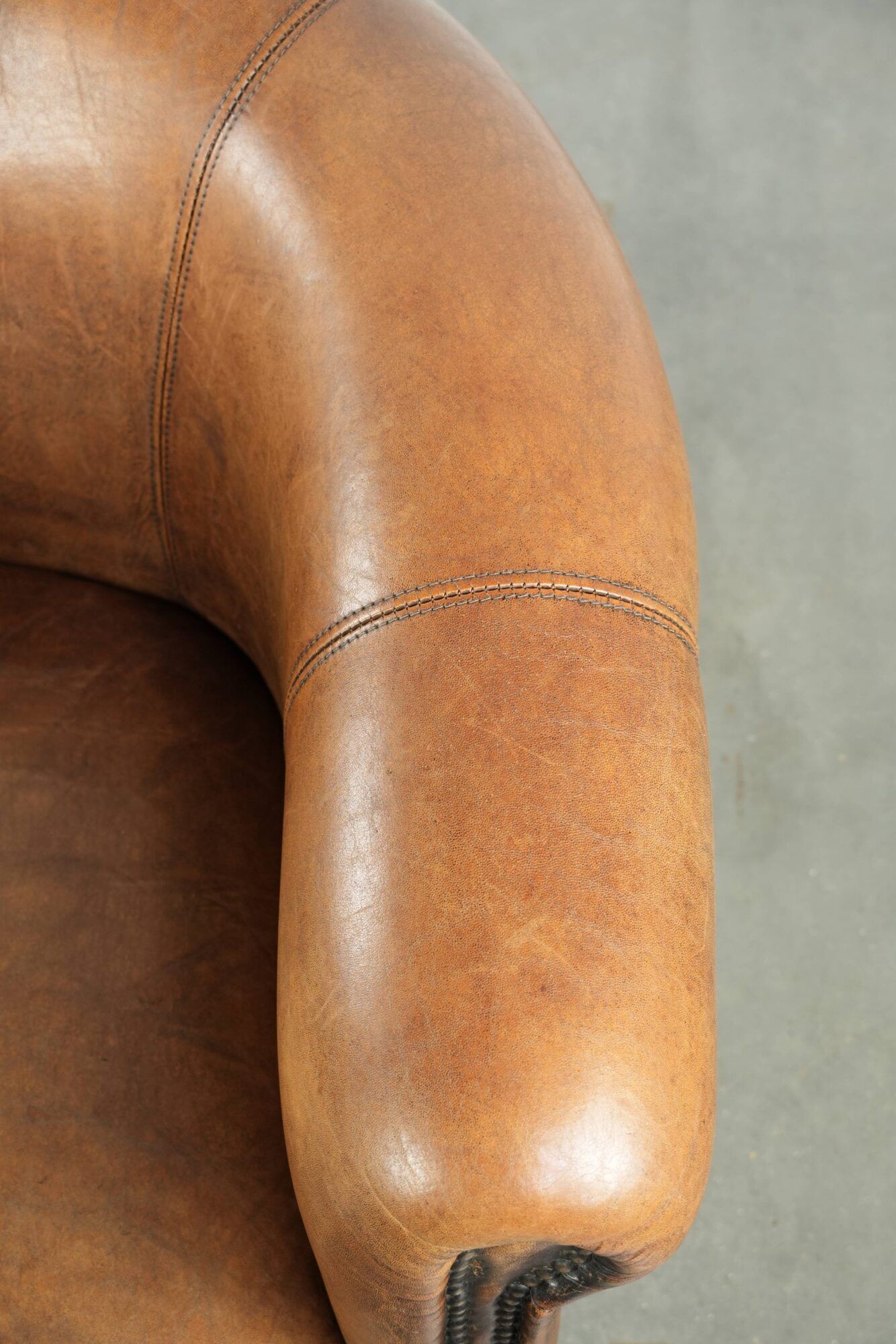 Sheepskin club armchair in a brown colour finished with decorative nails