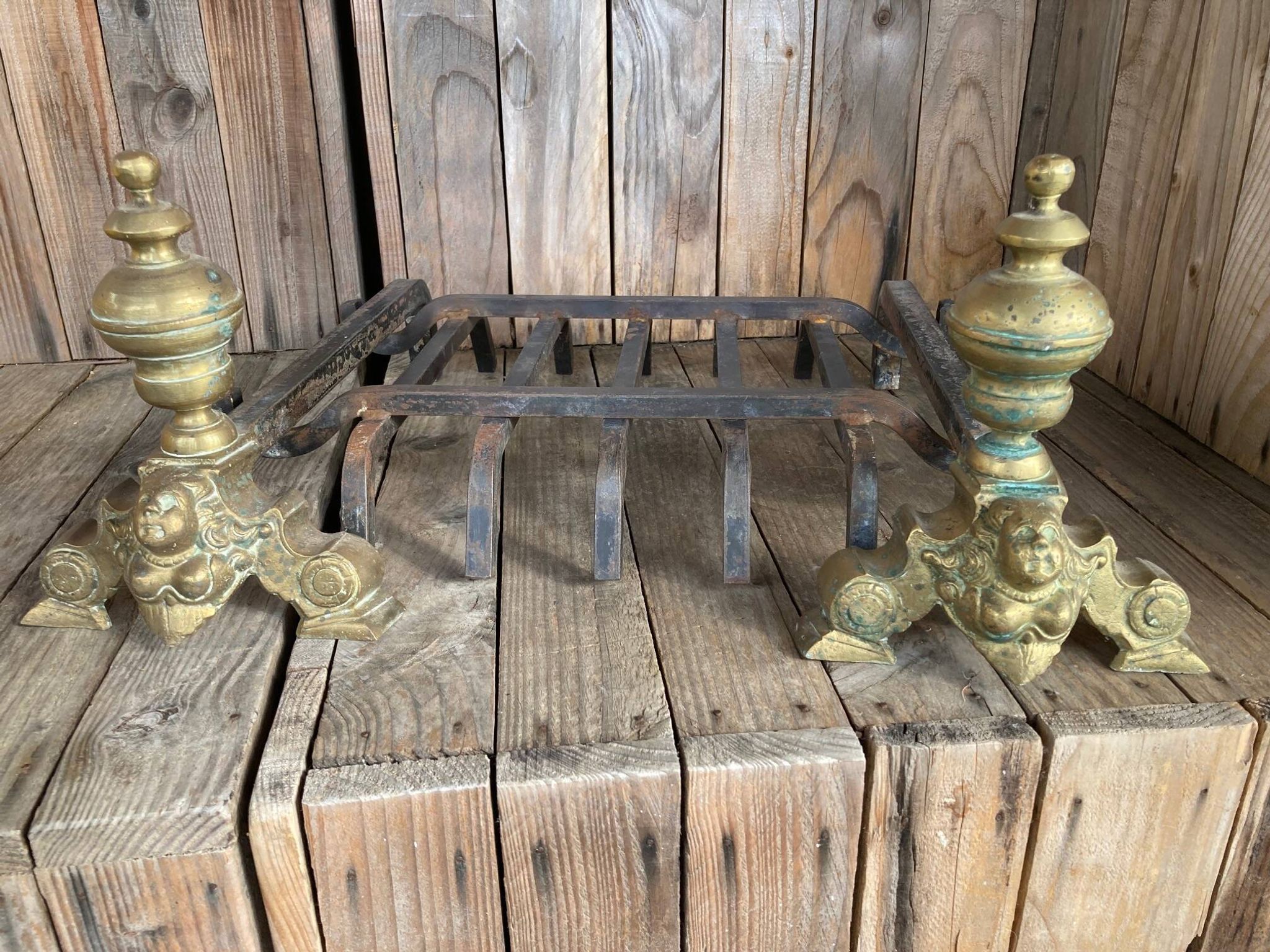 Pair of andirons and grates in cast iron and bronze with gilded grotesques, 17th century