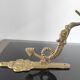 Vintage brass coat hook with marine creature motif and medallion.