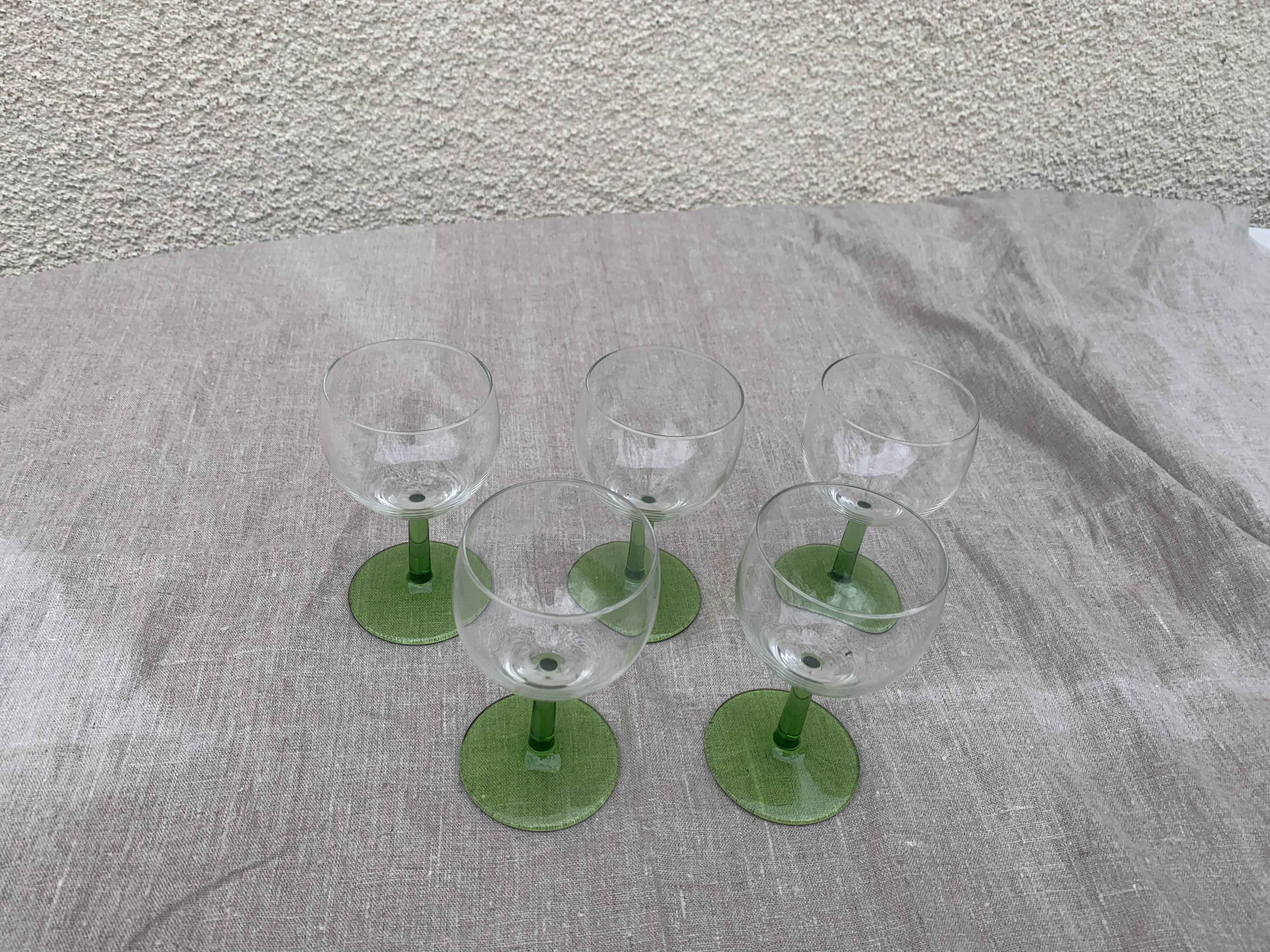 5 transparent glass glasses and green glass vase go