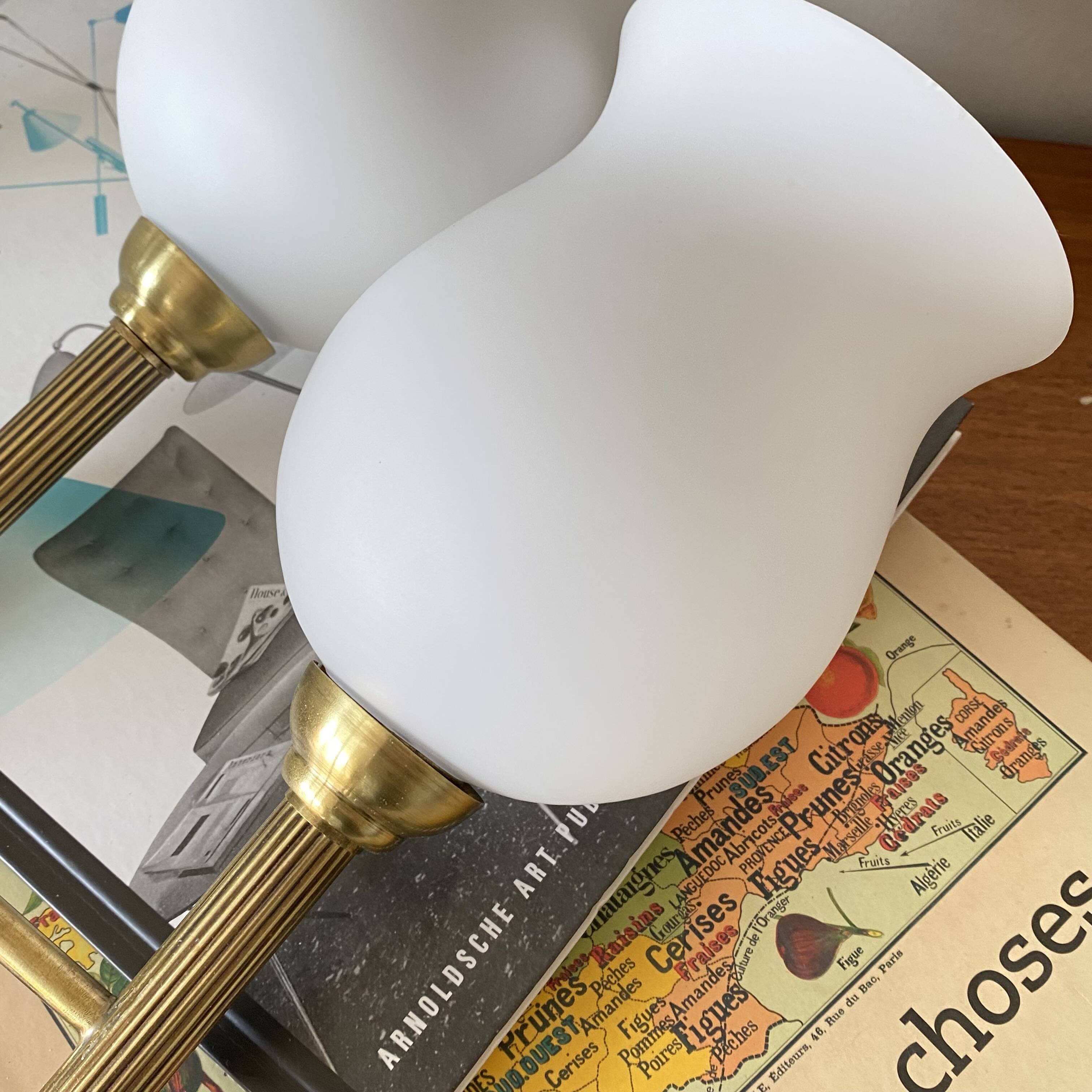 Pair of torch wall lights in brass, white glass and porcelain.