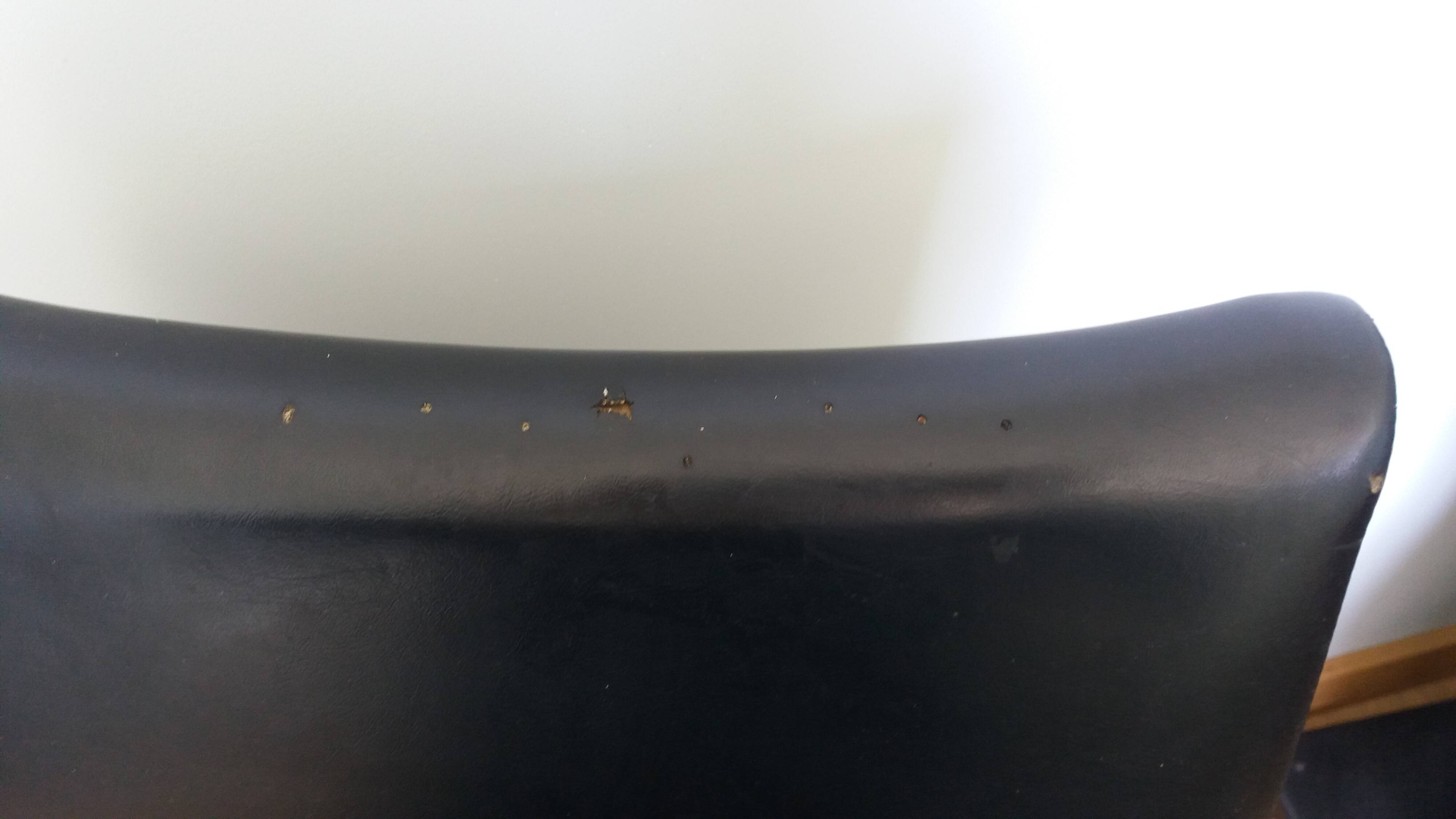 Chrome metal chairs and black faux leather upholstery in retro modernist style.