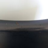 Chrome metal chairs and black faux leather upholstery in retro modernist style.