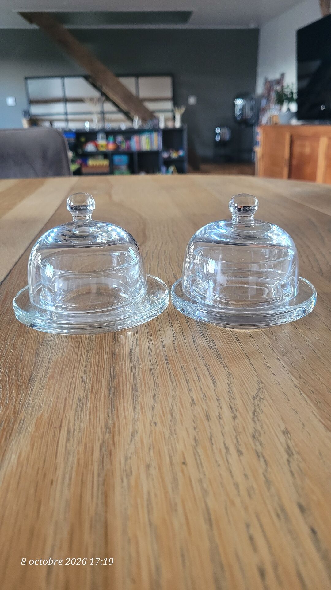 2 transparent glass butter dishes with their matching cloches.