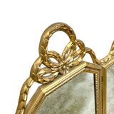 Triptych-shaped mirror in gilded wood and carved with a frieze
