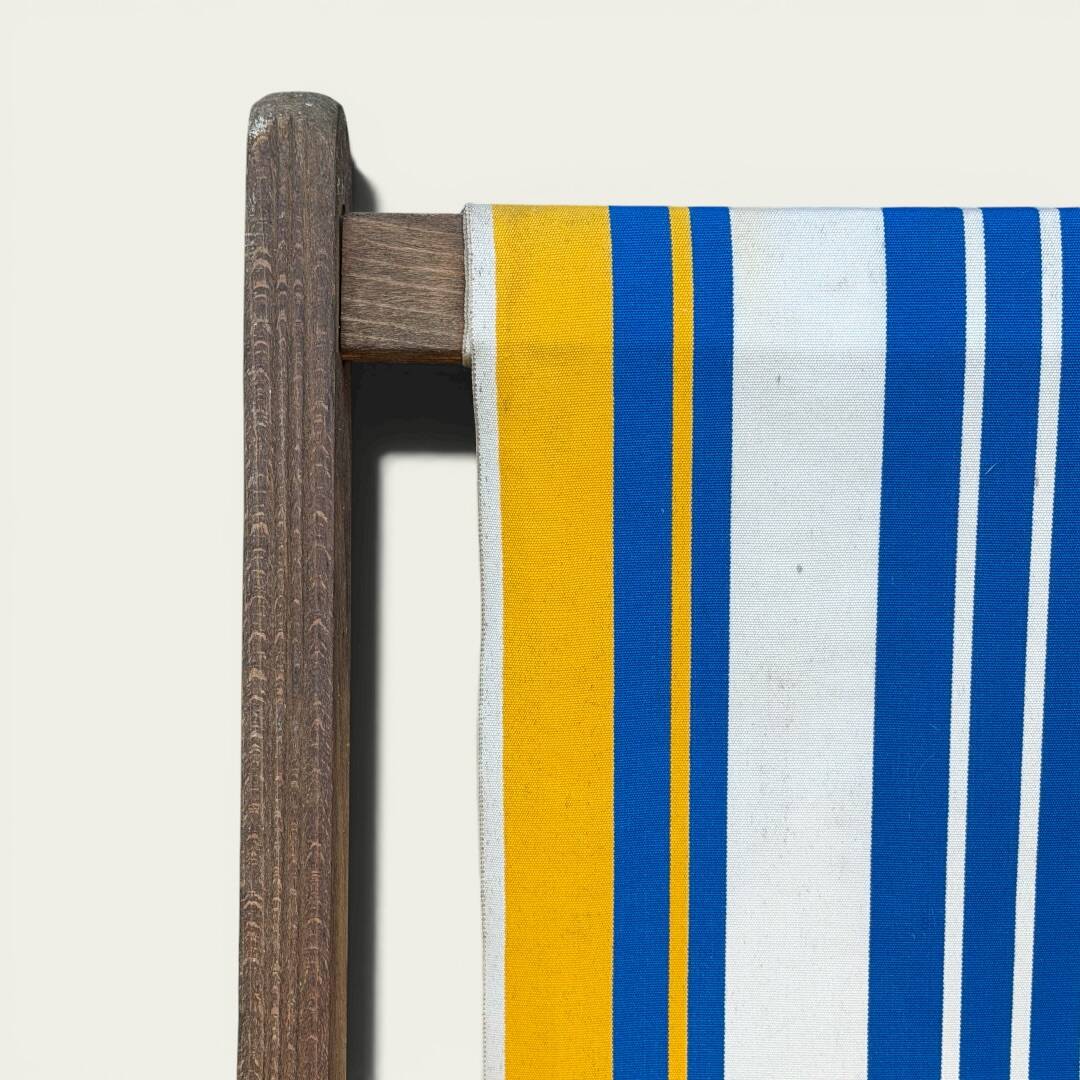 Vintage deck chair with blue and yellow striped fabric, original patina.