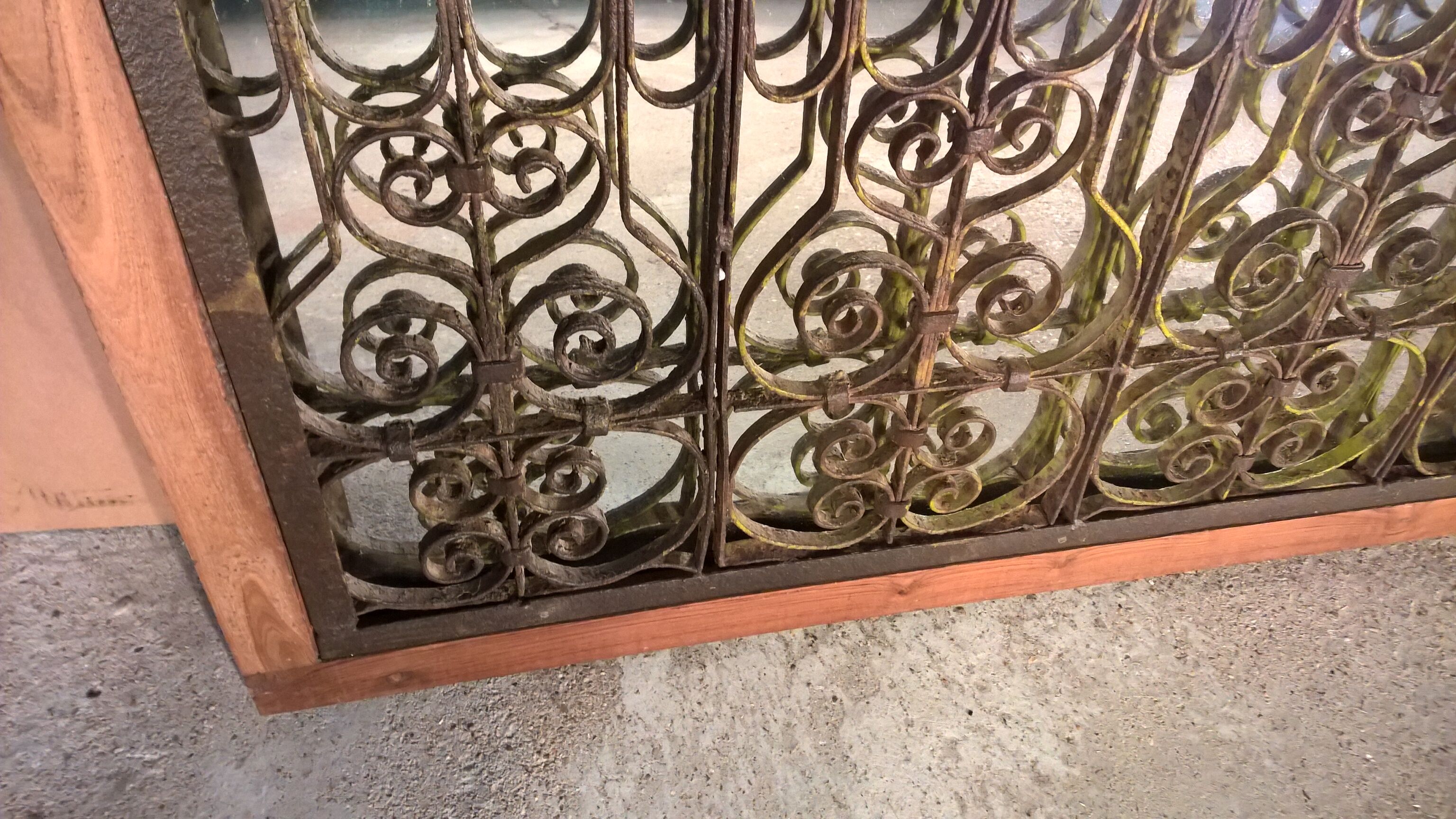 Old wrought iron railing with mirror and teak frame