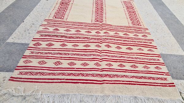 Tapis rouge et blanc à motifs éthniques traditionnel