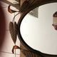 Miroir ovale entourage fer forgé en forme de fleurs et feuillage noir 69x55cm