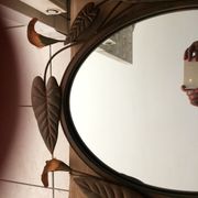 Miroir ovale entourage fer forgé en forme de fleurs et feuillage noir 69x55cm