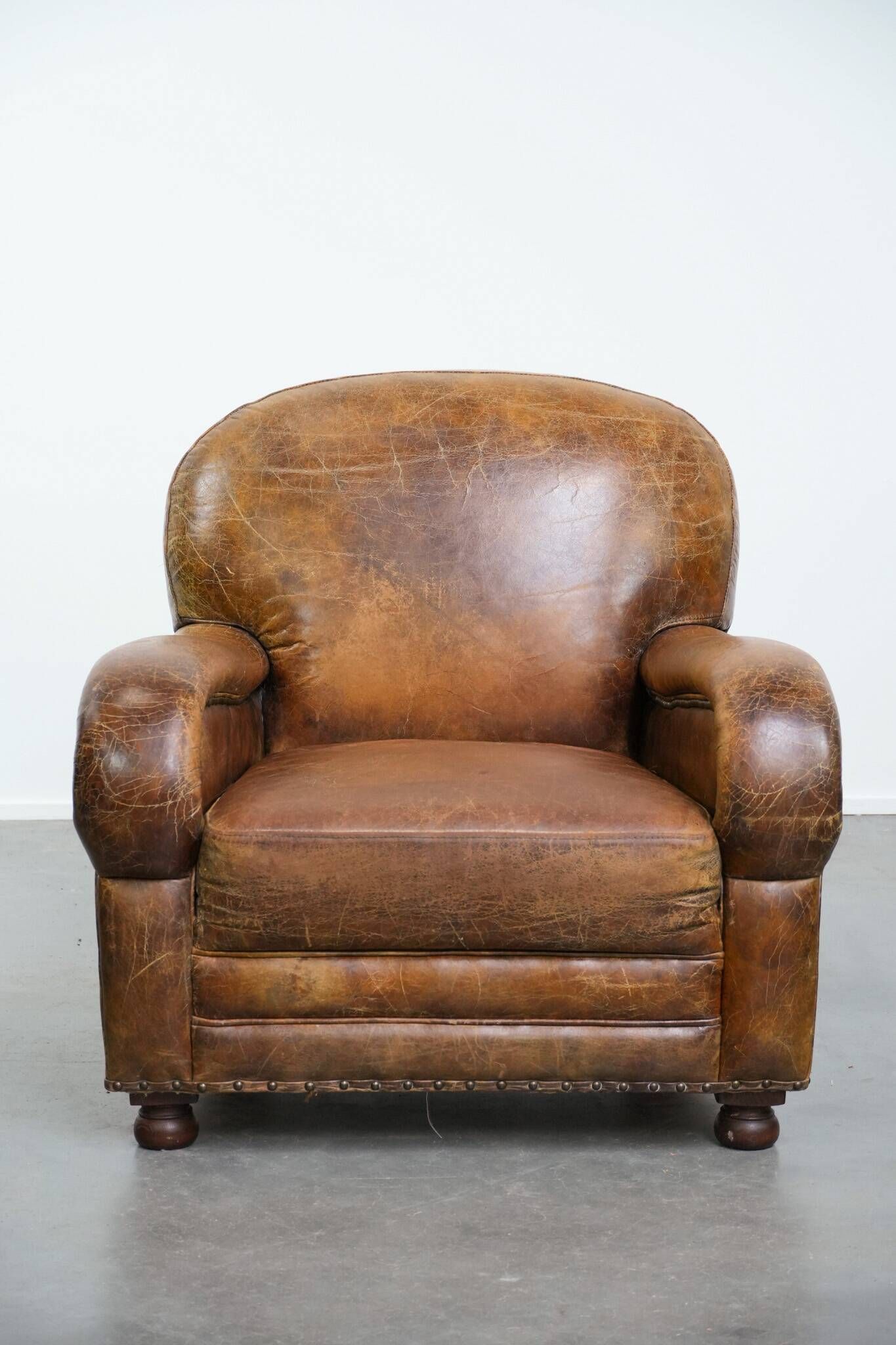 Charming and comfortable vintage armchair in grained cowhide leather with character
