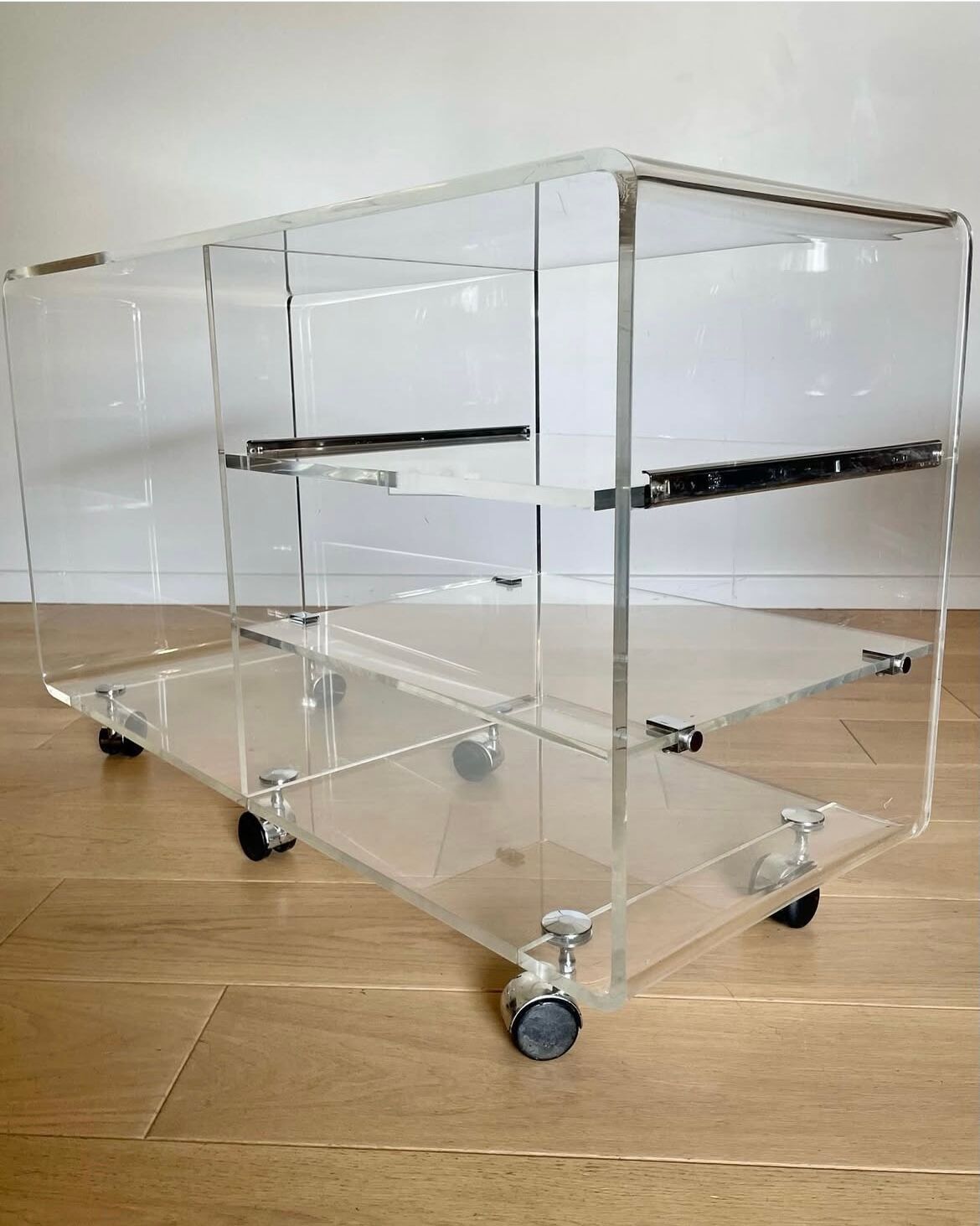 Shelf on wheels, transparent plexiglass TV stand.