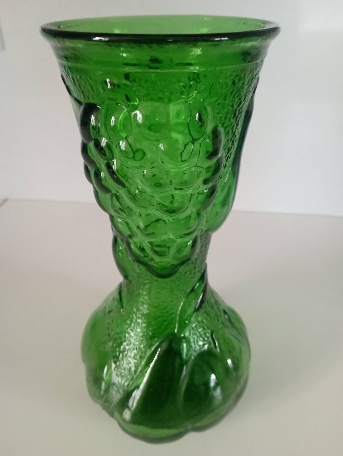 Green glass vase decorated with bunch of grapes and fruits