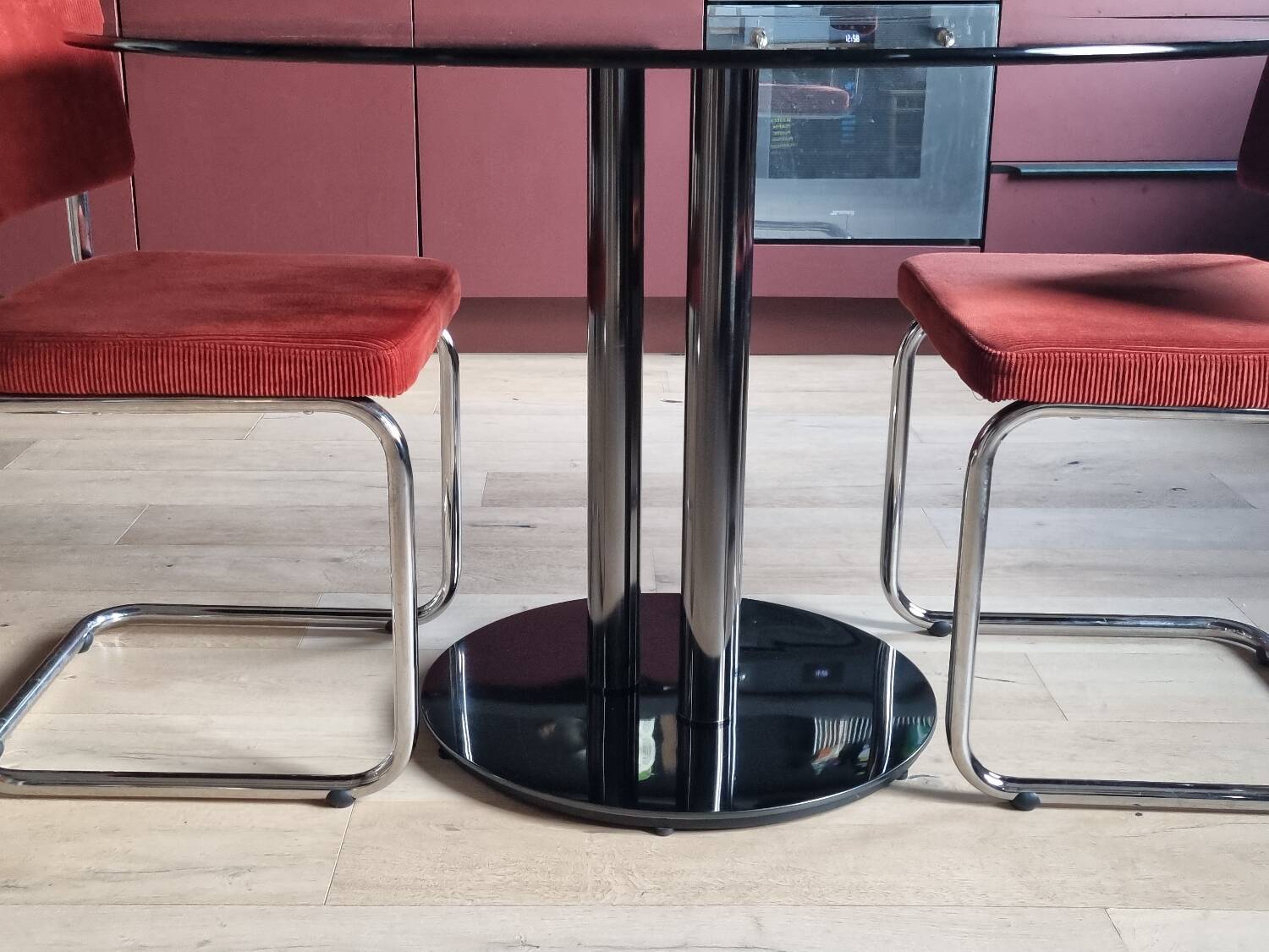 Round black smoked glass dining table + 2 terracotta chairs