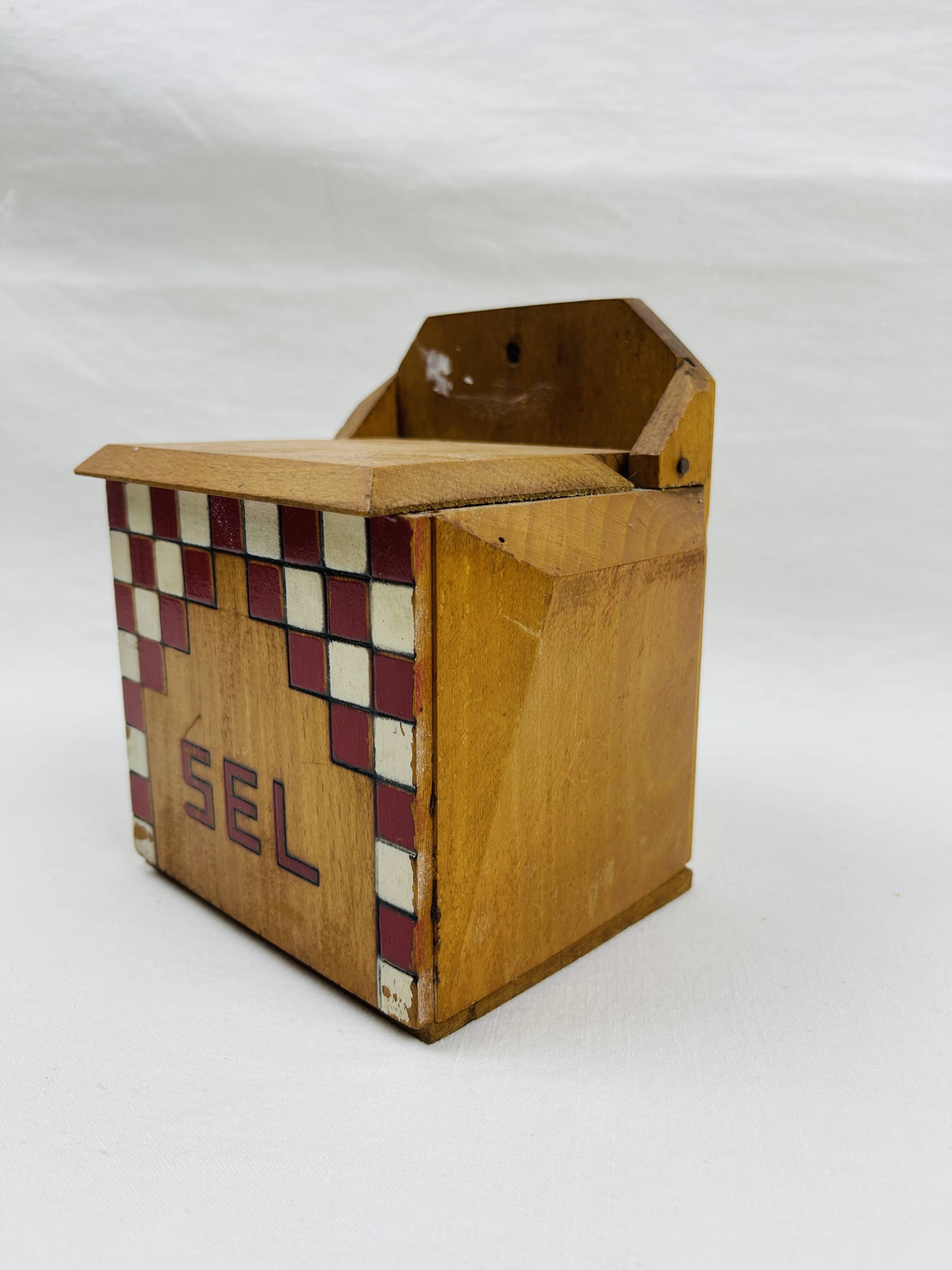 Old wooden salt box with red and white checkerboard decoration