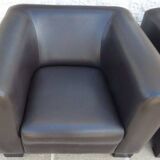 2 club armchairs with a chocolate faux leather seat and backrest and wooden legs.