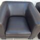 2 club armchairs with a chocolate faux leather seat and backrest and wooden legs.