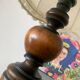 Small vintage wooden turned table lamp with a pleated shade.