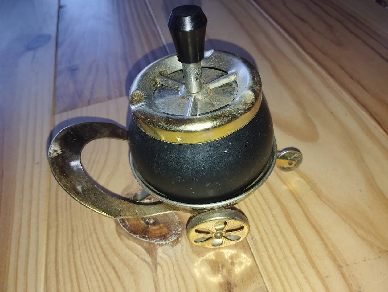Original vintage ashtray on a small wheeled stand.