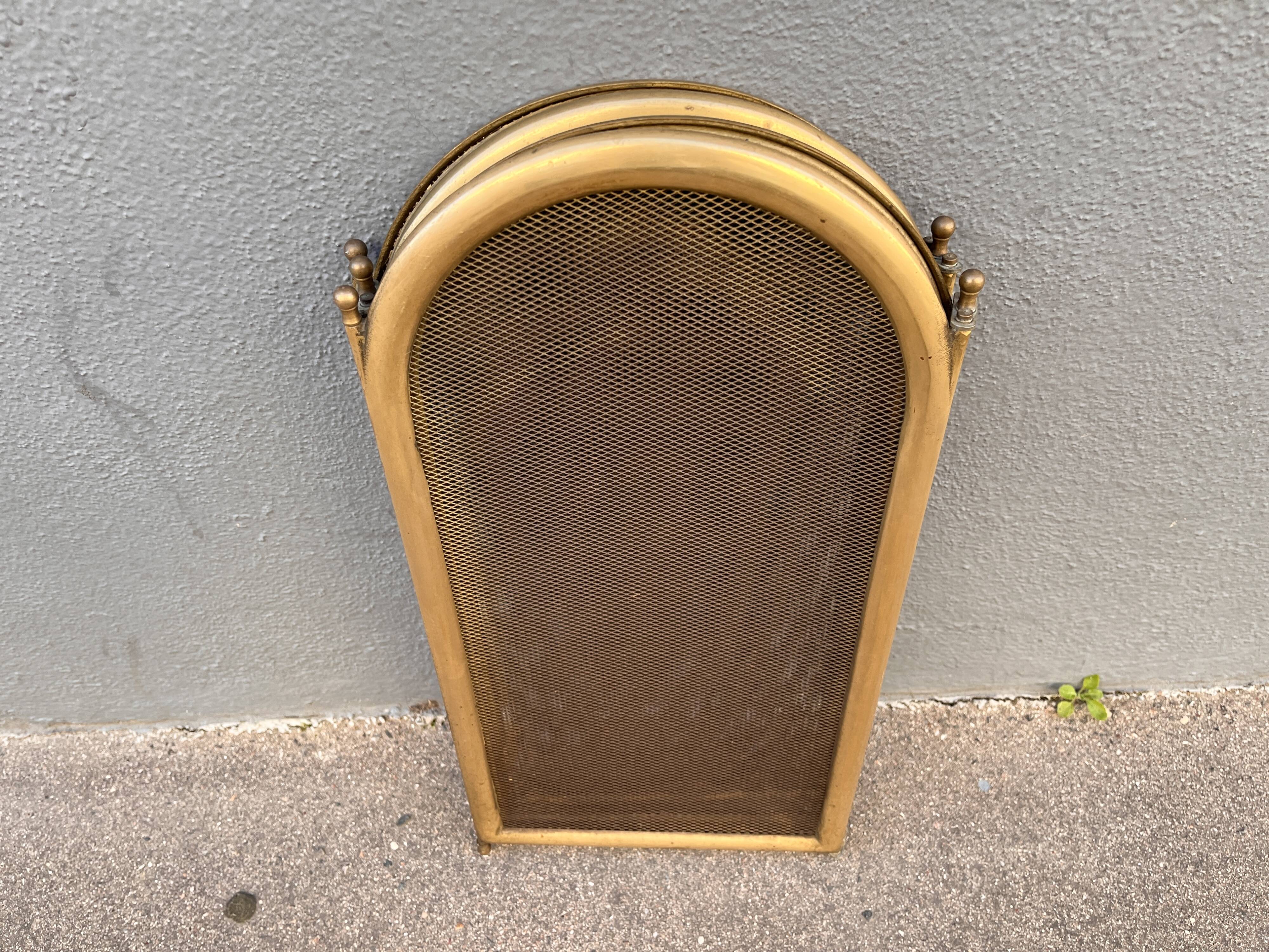 Antique brass fireplace screen from 1920, vintage spark guard.
