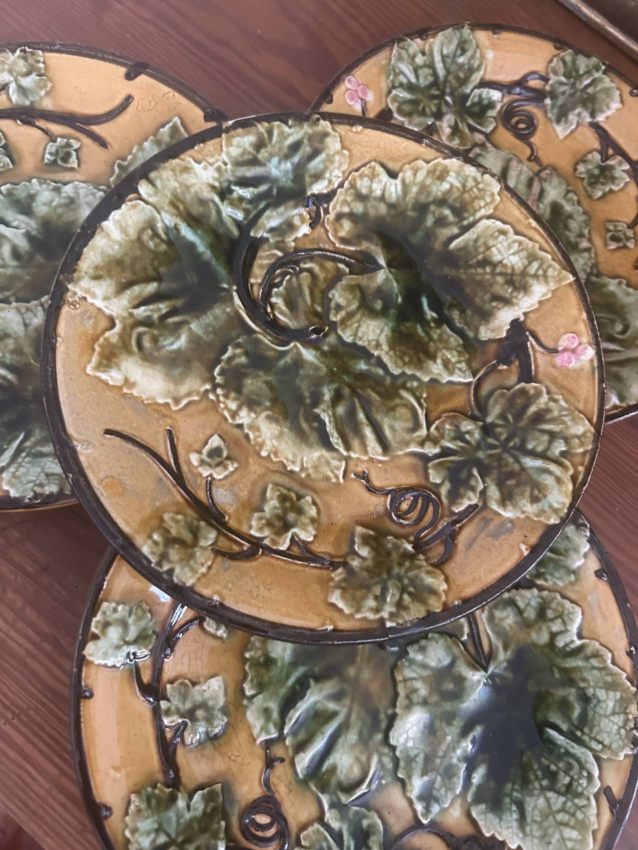 Four antique dessert plates in majolica with vine decoration.