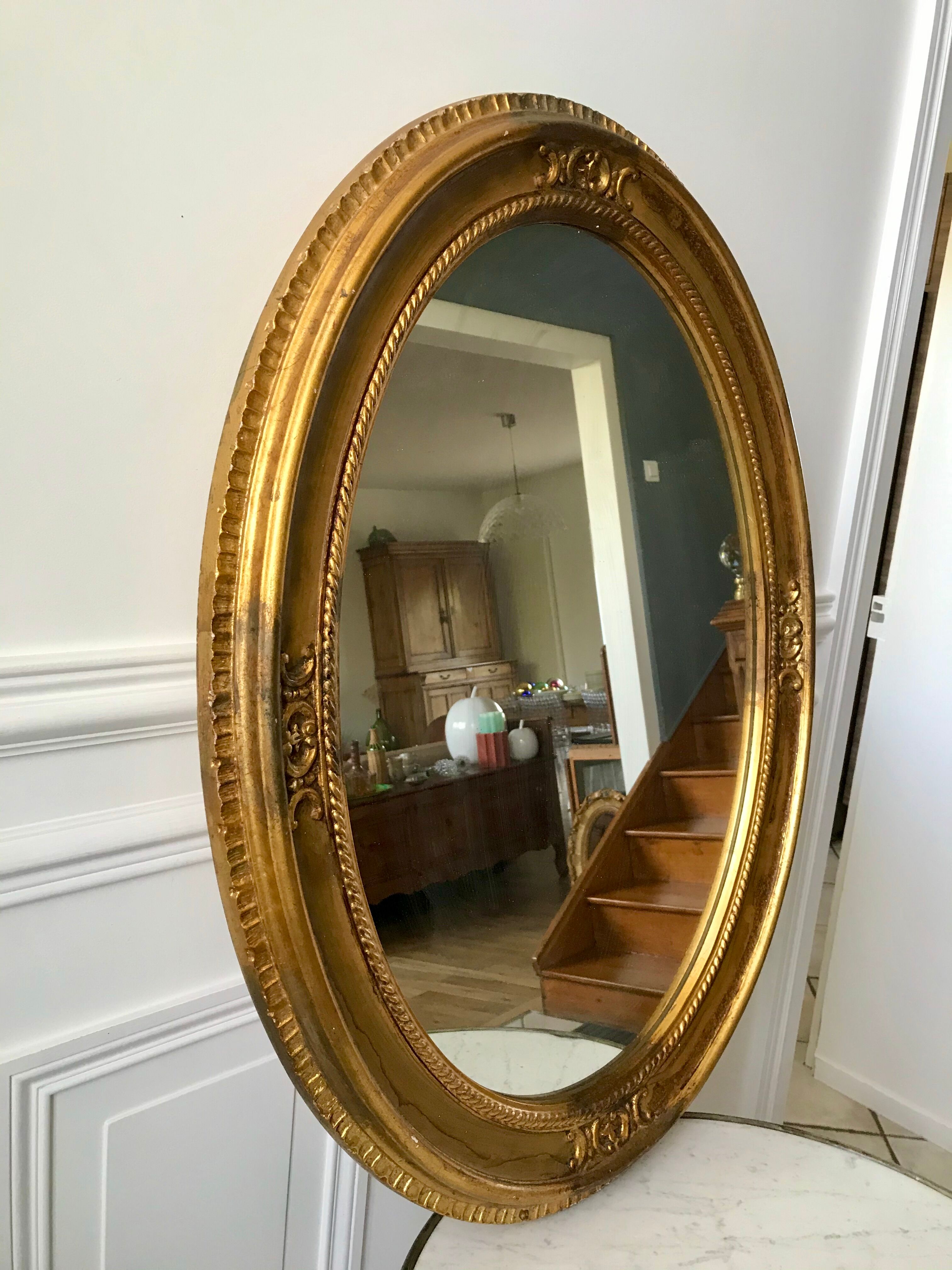 Grand miroir oval en stuc doré vintage