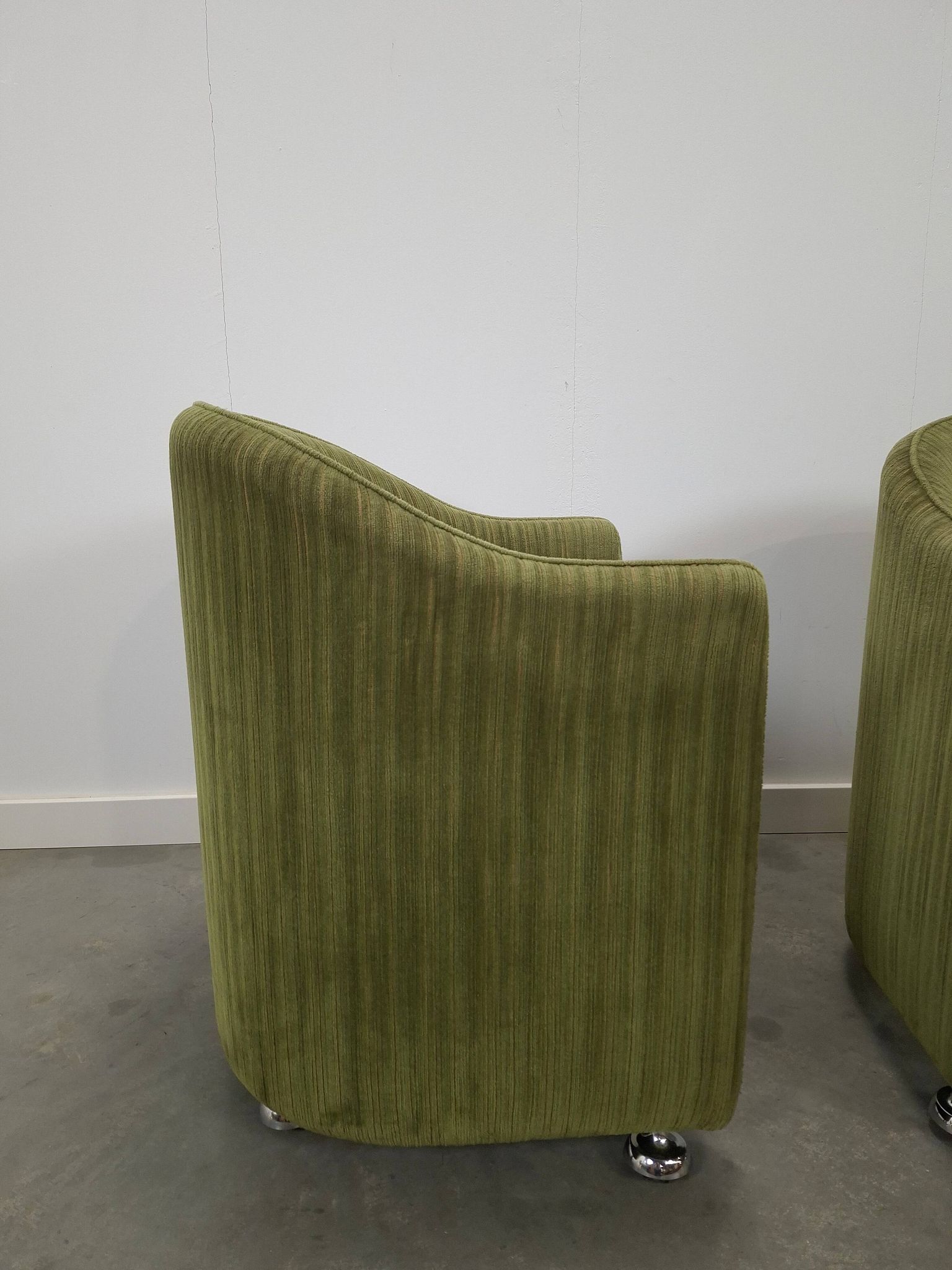 Chaises de cocktail vertes avec des roues chromées.