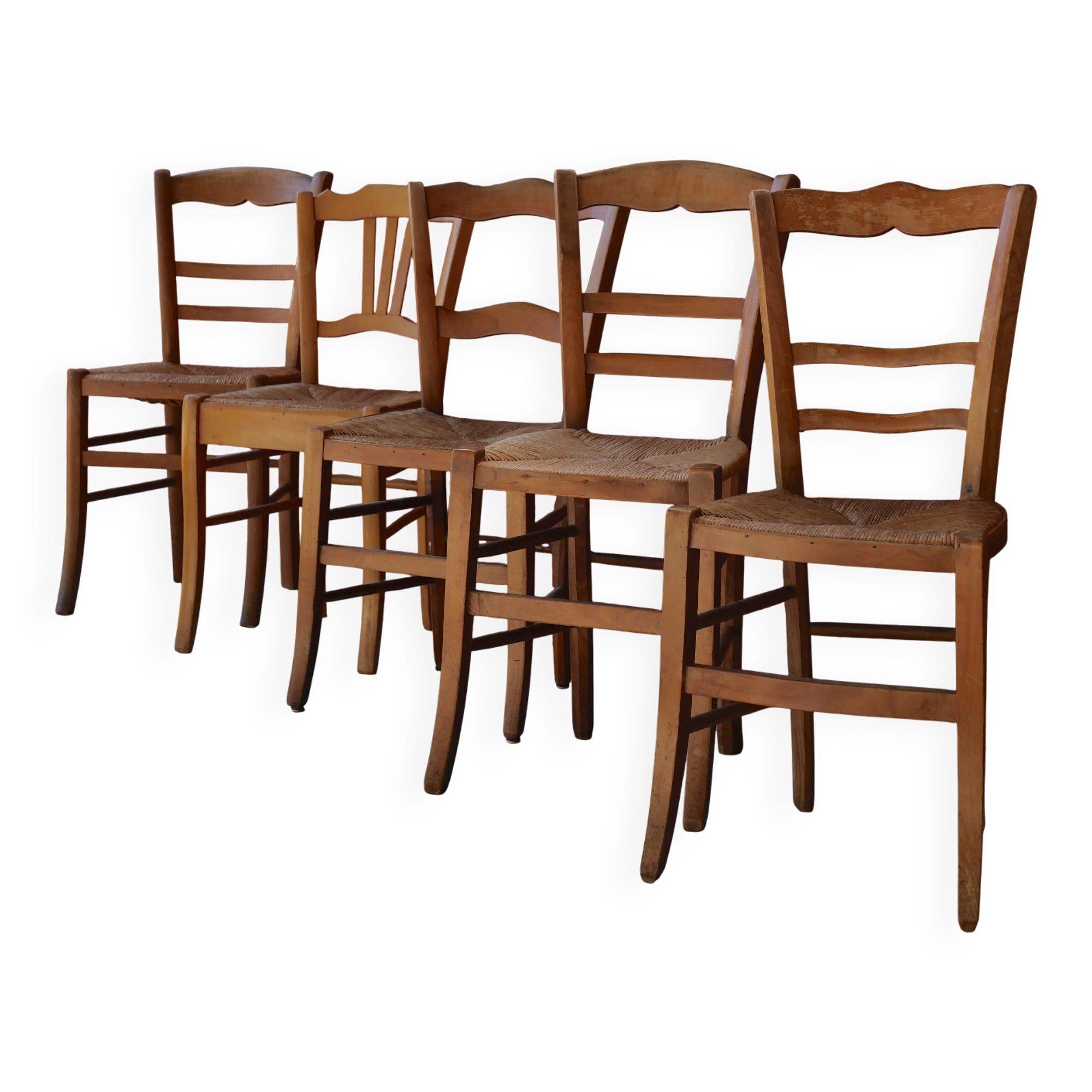 Set of 5 mismatched straw chairs.