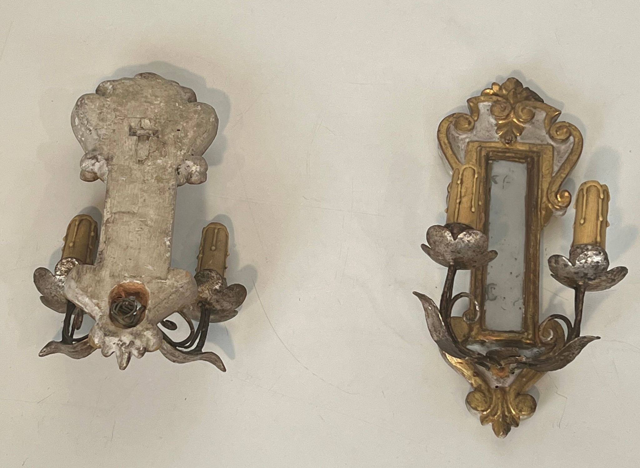 Pair of wall sconces in carved wood and silvered and gilded patinated metal with a central mirror.