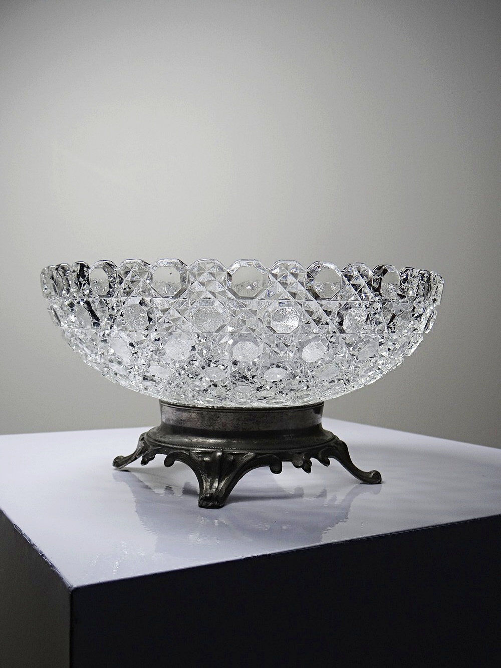 Pressed glass coupe with diamond points, antique from 1920-1950 on a pewter base.