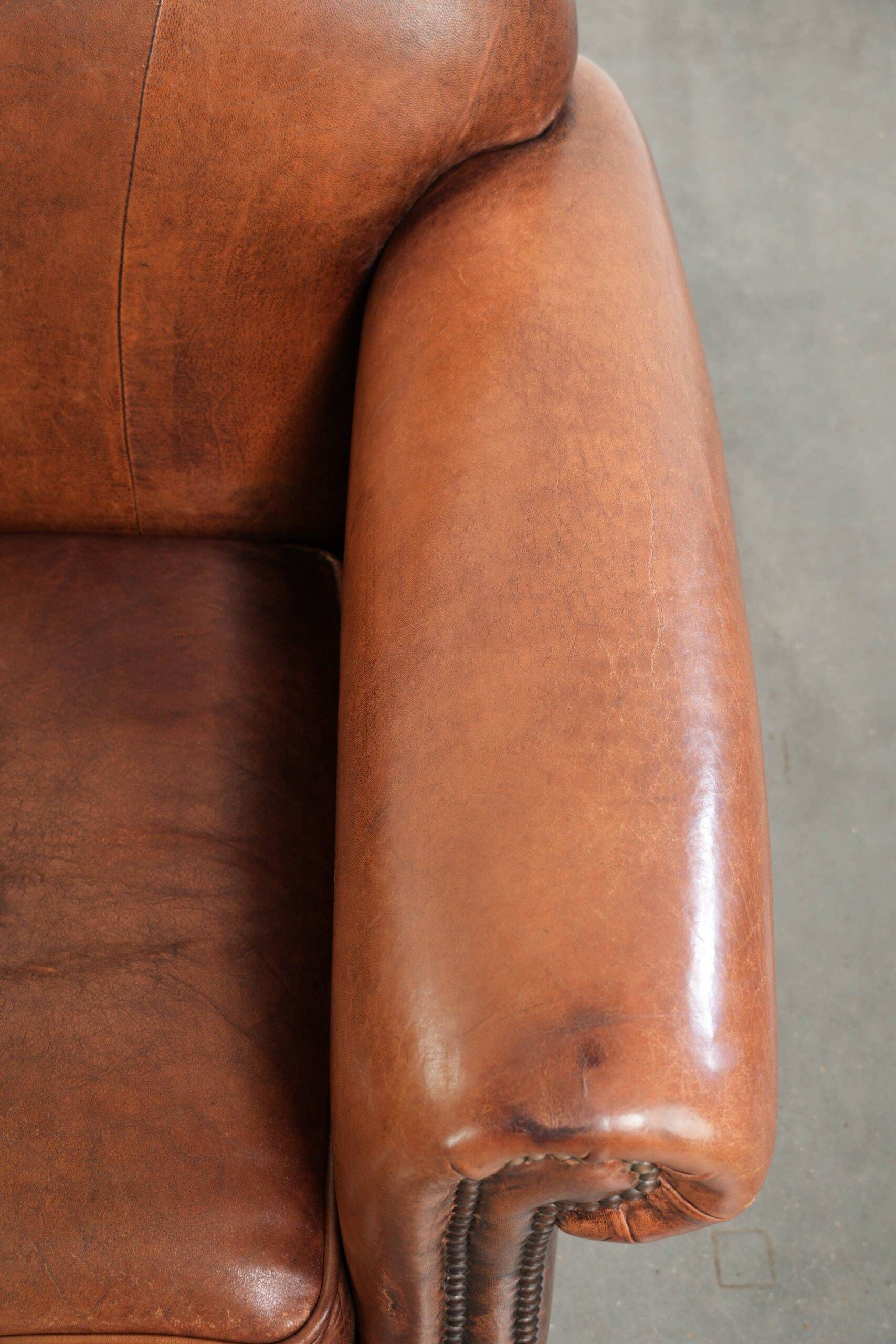 Comfortable vintage sheepskin armchair finished with decorative nails
