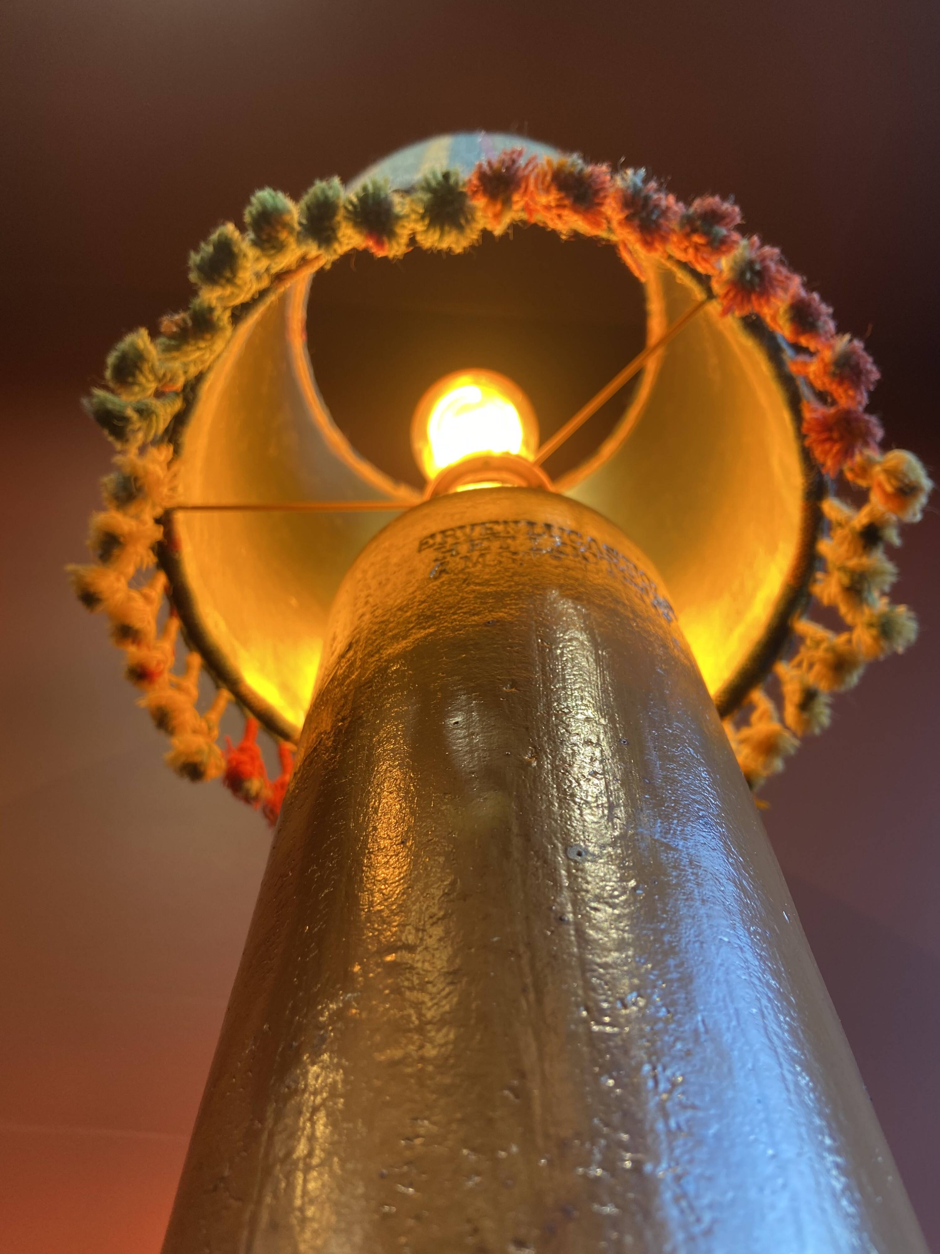 "Stoneware Bottle Lamp" with a multicoloured blue lampshade handwoven in India.