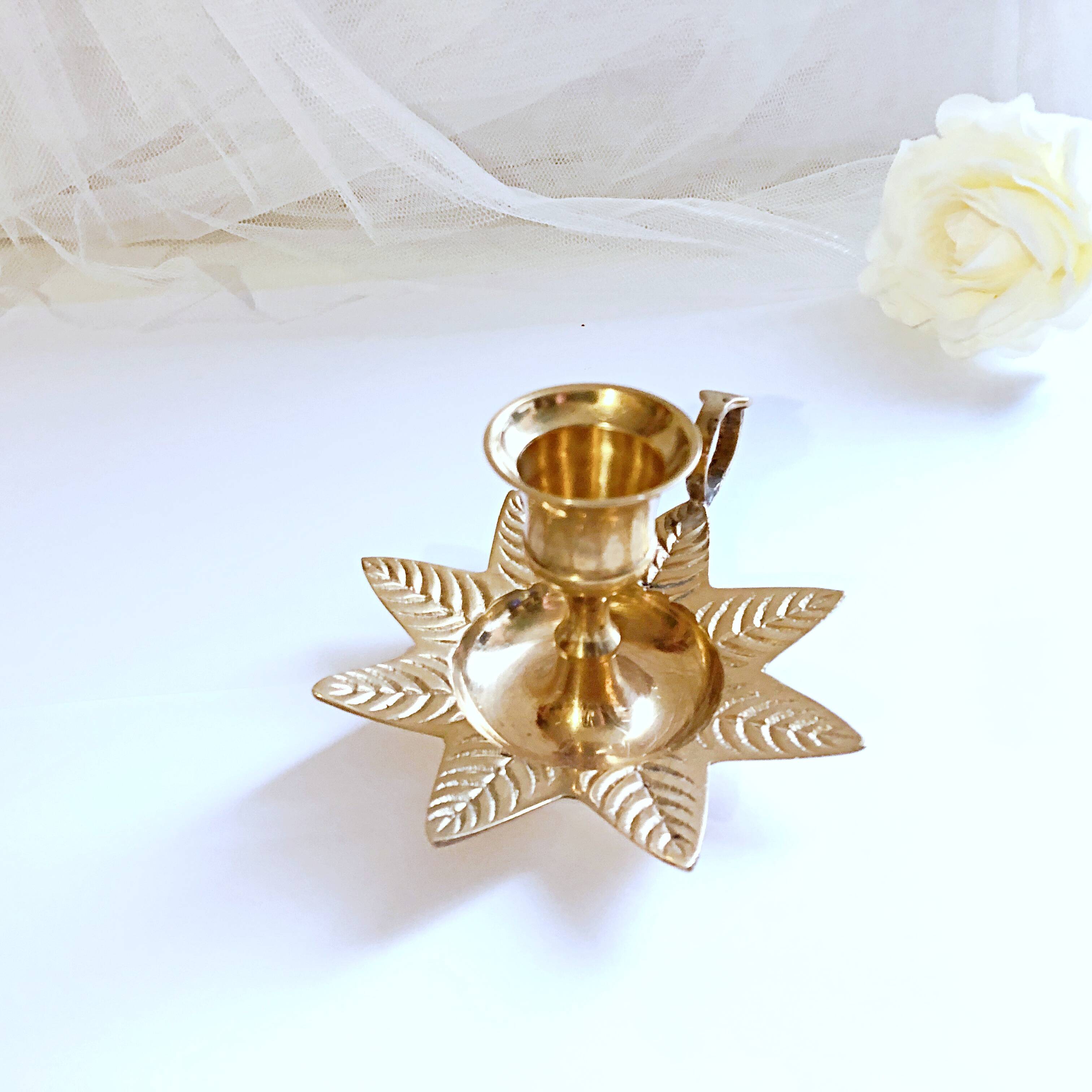 Golden brass hand candle holder decorated with leaves