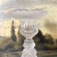 Tall molded glass candle holder with ram heads