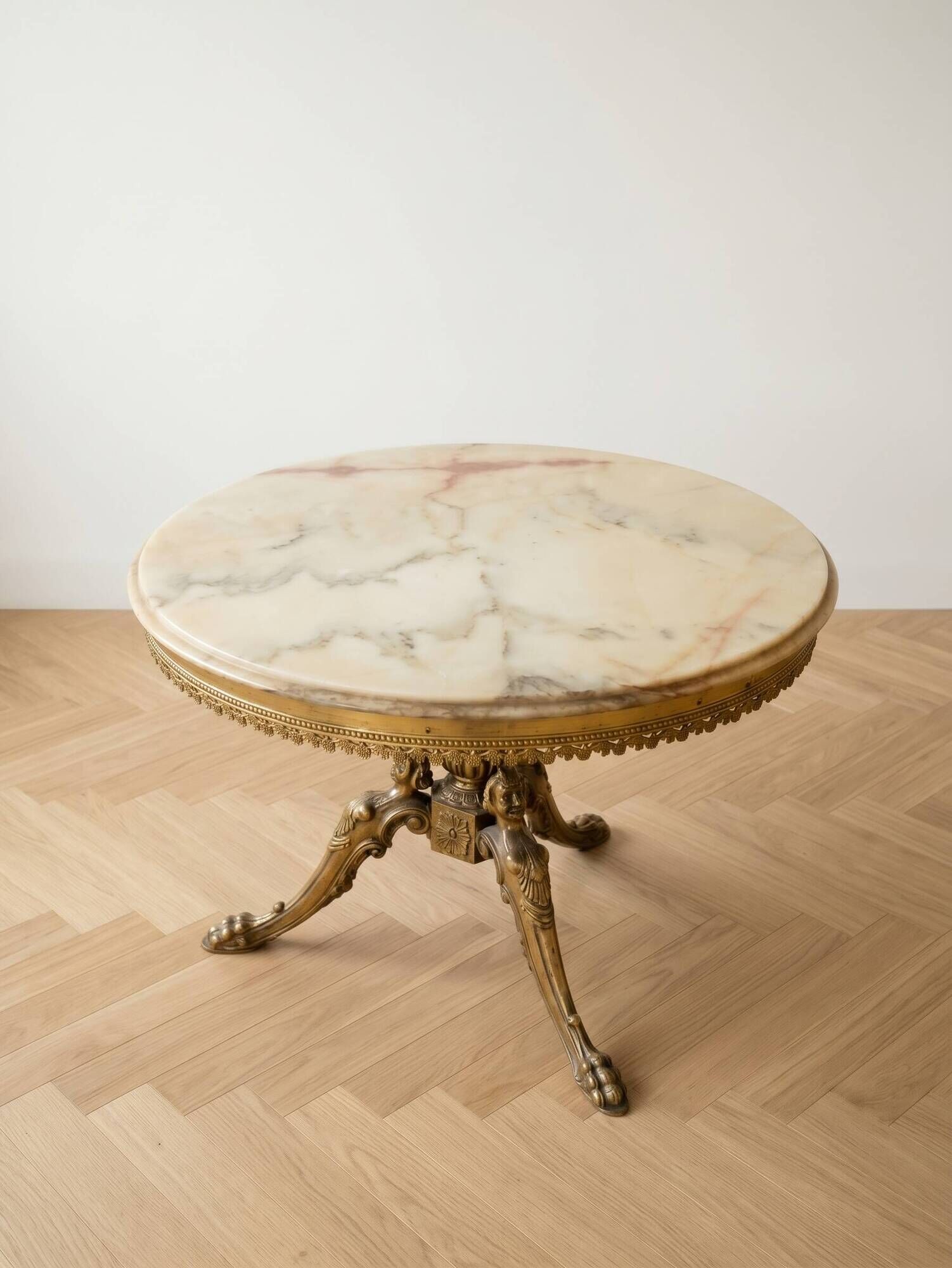 Round marble coffee table with a gold base in classic style.