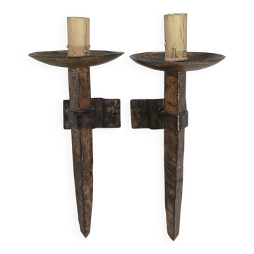 Pair of brutalist wall sconces in hammered and patinated iron, work from the years.