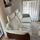Ecru leather 2.5-seater sofa with walnut armrests.