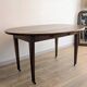 Antique wooden folding table with a patina and brass wheels.