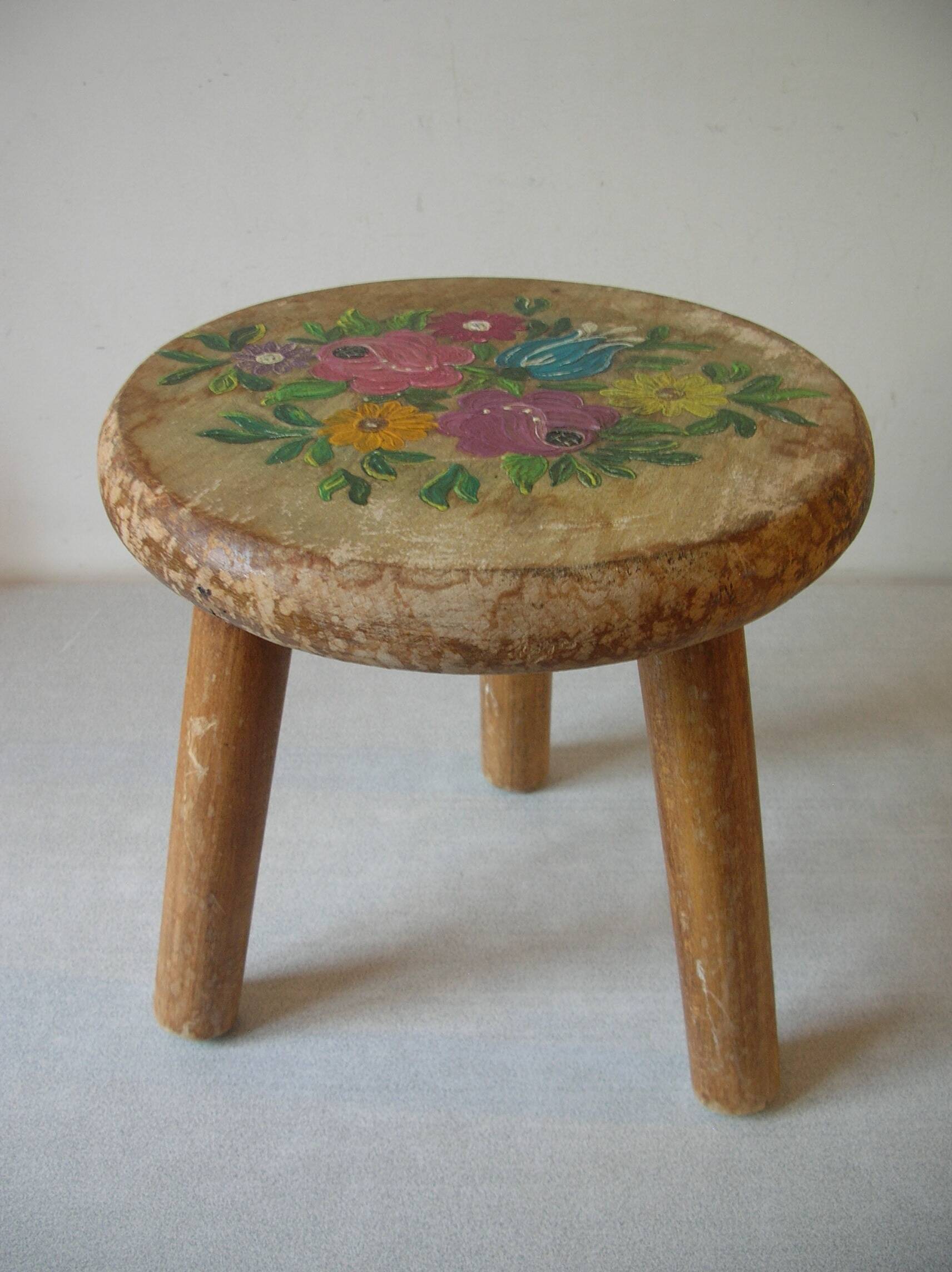 Old tripod stool with 3 wooden legs, painted floral decoration, flower bouquet