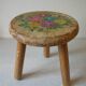 Old tripod stool with 3 wooden legs, painted floral decoration, flower bouquet