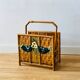 Vintage rattan magazine holder with floral decoration