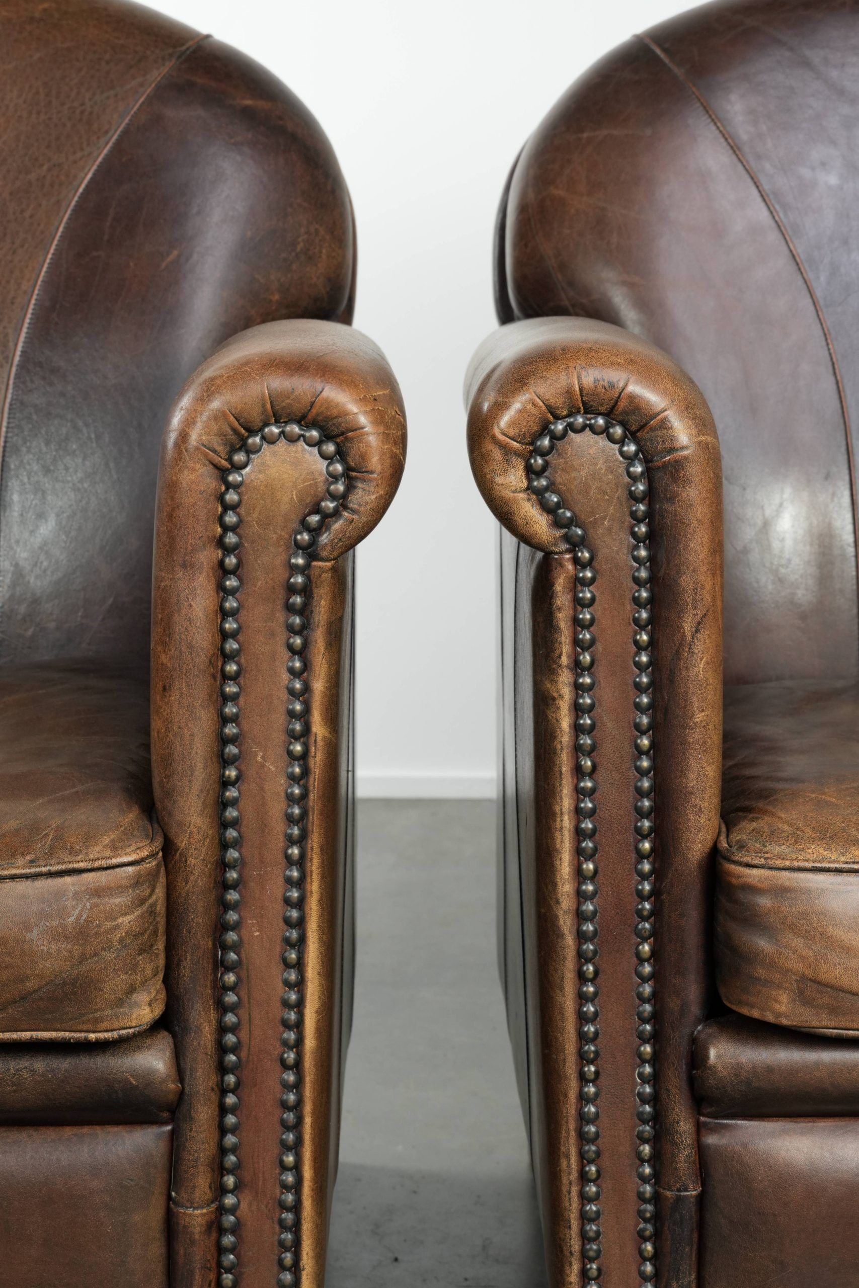 Characterful set of two sheepskin design armchairs with beautiful patina