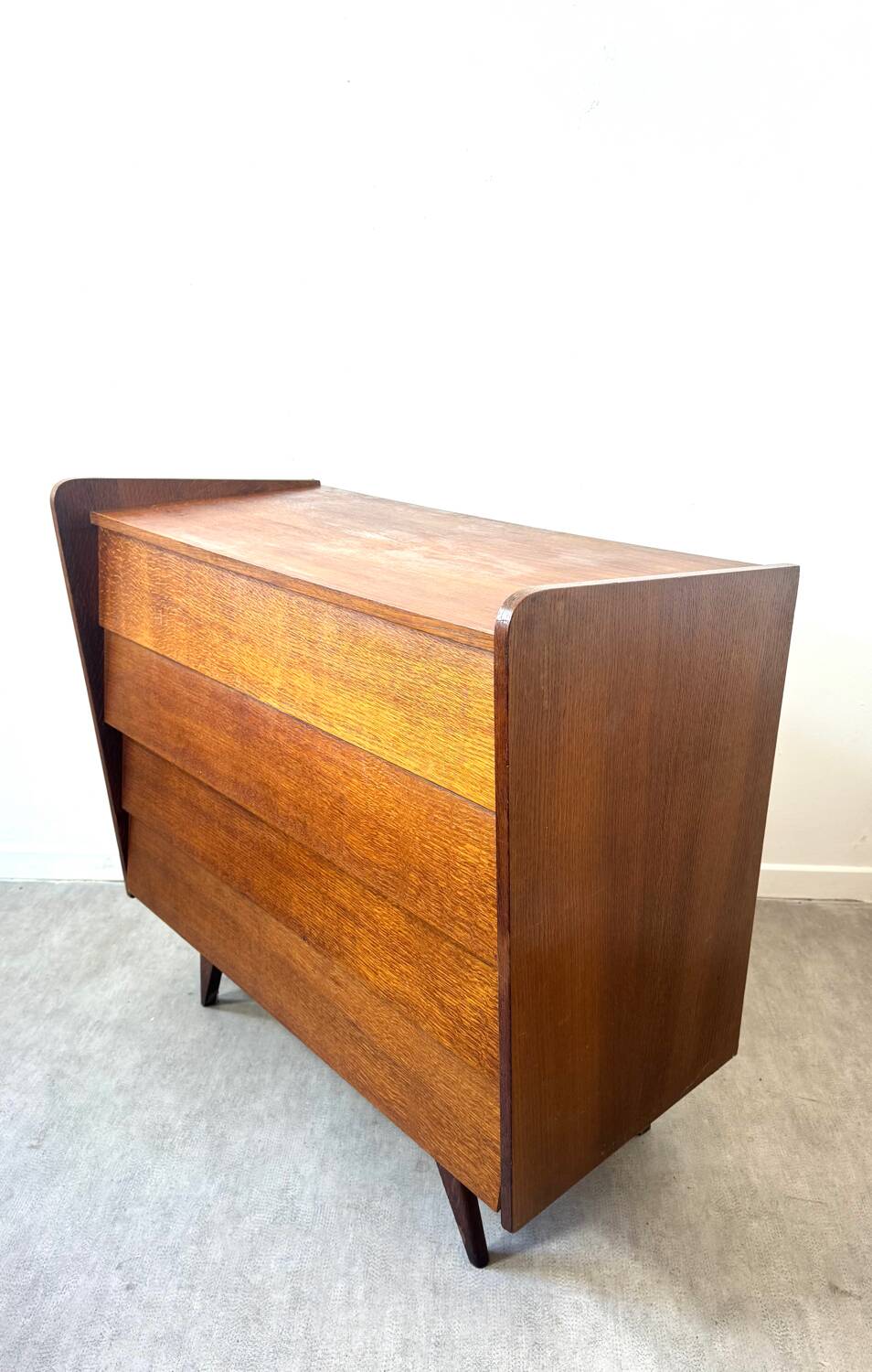Vintage wooden chest of drawers with tapered legs.