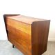 Vintage wooden chest of drawers with tapered legs.