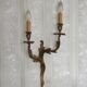 Apply two bronze wall lights decorated with acanthus leaves.