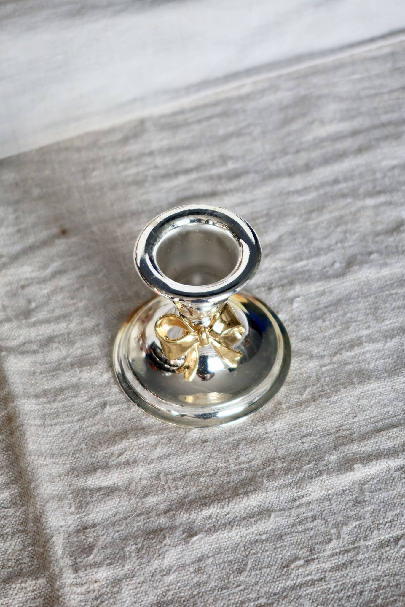 Small vintage silver-plated metal candlestick with a gold bow